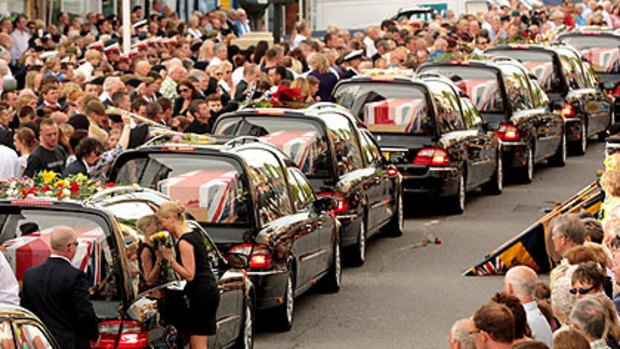 Crowds line the main street of Wootton Bassett in Wiltshire as the bodies of seven servicemen killed in Afghanistan are repatriated to Britain.