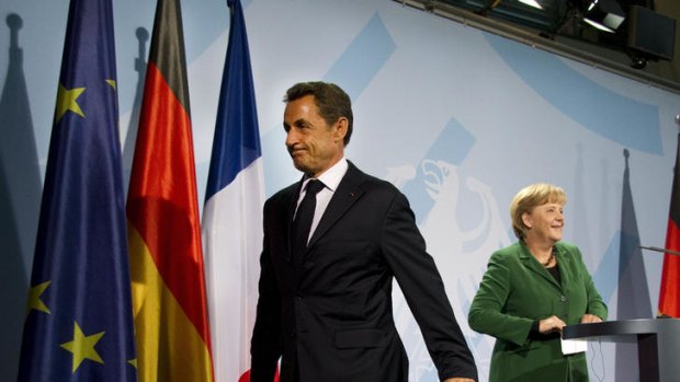 German Chancellor Angela Merkel and French President Nicolas Sarkozy leave after giving a statement at the Chancellery in Berlin.