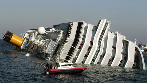 Every ferry from the mainland disgorges sniffer dogs, cave-diving experts and journalists, while in the background looms the Costa Concordia, a capsized, white tower-block outside the harbour.