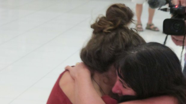 Camille Thomas collapses into the arms of her mother Kate Thomas at Bangkok airport. Camille is suffering from frost bite on her feet.
