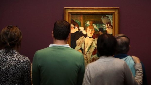 Visitors to the National Gallery of Australia look at the work La Goulue entering the Moulin Rouge during Toulouse Lautrec exhibition.