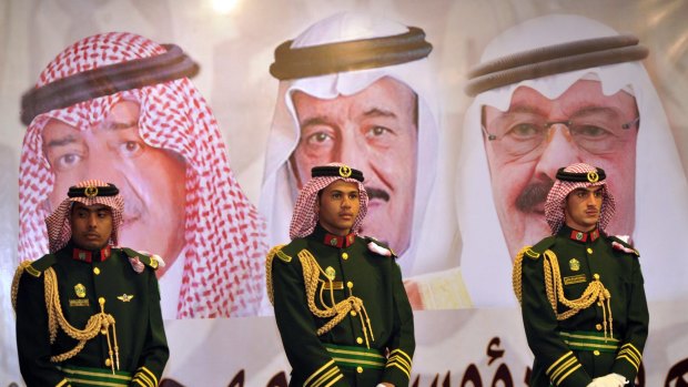 Saudi royal guards stand on duty in front of portraits of the late King Abdullah (right), his successor King Salman (centre) and new Crown Prince Muqrin in February 2014.