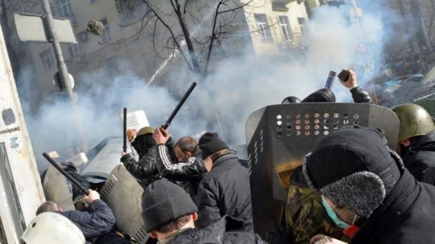 Protesters throw rocks at police in front of the Ukranian Parliament on Tuesday.