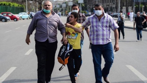 Extra powers: Policemen in plain clothes arrest an Egyptian youth following two explosions at Cairo University on April 14.