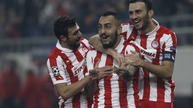 Olympiakos' Kostas Mitroglou, centre, celebrates after scoring against Arsenal.