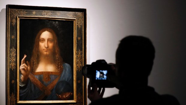 A visitor films Leonardo da Vinci's 'Salvator Mundi' on display at Christie's auction rooms.