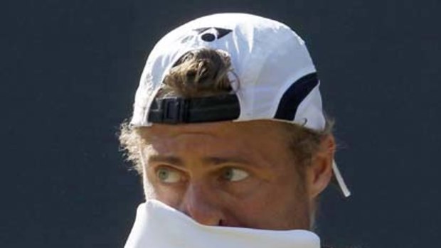 Lleyton Hewitt wipes his face after missing a point against Novak Djokovic.