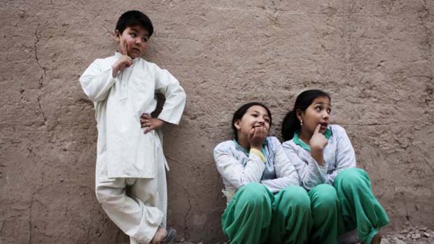 Mehran Rafaat (left) with her twin sisters Benafsha and Beheshta outside their family home in Kabul. Mehran, 6, is regarded as a boy by her family.