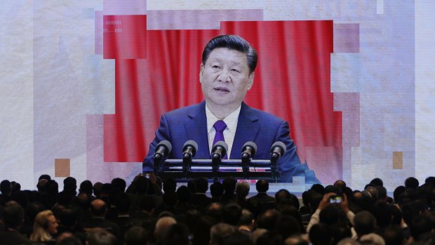 A screen shows Chinese President Xi Jinping during a symposium in Hong Kong.