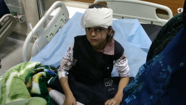 An injured girl waits for treatment at a hospital after a suicide bomber set off an explosive-laden car in a school playground.