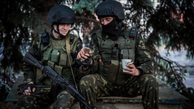 Brief respite ... Ukrainian government soldiers look at a mobile phone while resting at a checkpoint near Slovyansk, Ukraine.