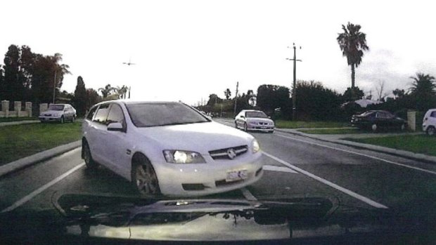 A photograph taken from the dashboard of the family’s car shows the stolen Commodore seconds before impact. Police would like to talk to the driver of a silver car behind the Commodore.