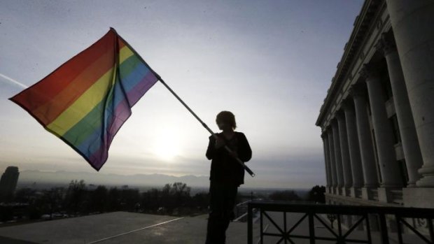 A supporter of gay marriage waves a rainbow flag outside the Utah State Capitol.