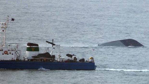 A South Korean naval ship, the Cheonan, sinks as a coast guard vessel sails near the ship in an attempt to rescue its sailors near South Korea's Baeknyeong Island.
