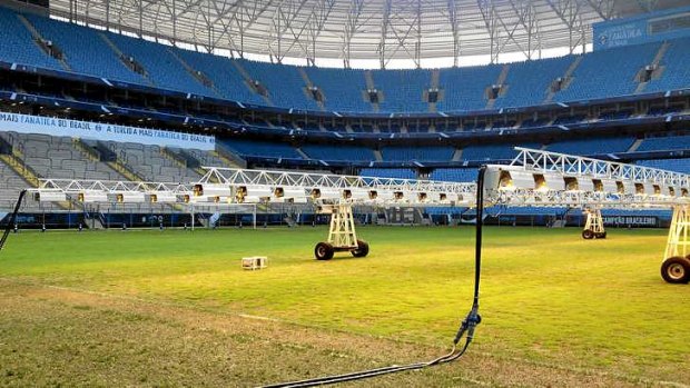 Giant lighting rigs help to grow the reseeded pitch at the new Gremio Arena which will be a training venue during the World Cup.