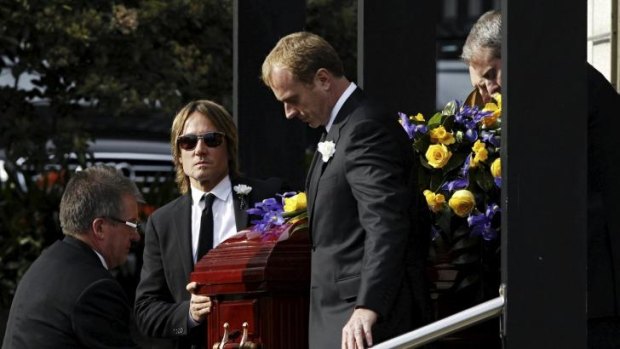Much loved father and friend: Keith Urban (centre) helps to carry Dr Kidman's coffin.