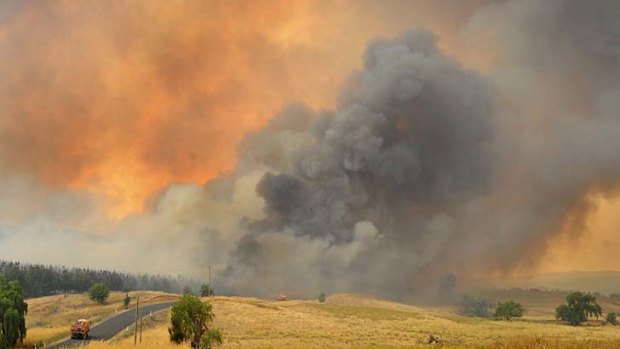 Going into battle: A fire truck heads towards a massive fire that caused an emergency warning to be issued after a wind change put 30 homes at risk in villages near Wagga Wagga on Sunday.