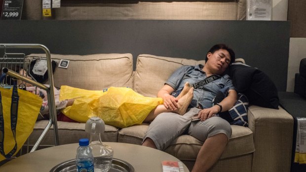 A man takes a nap on a display couch at an Ikea store in Beijing.