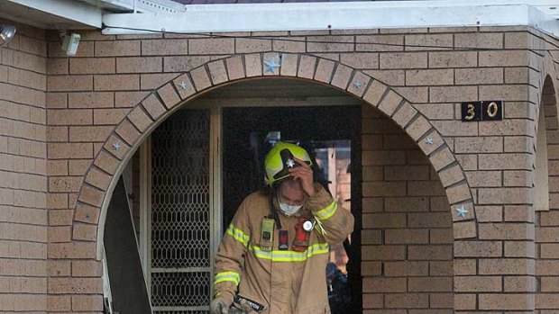 A firefighter emerges from the house at Clayton South, where a woman and two children are believed to have perished.