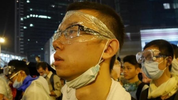 Simple shield: A protester wears makeshift protection as  demonstrations grow.