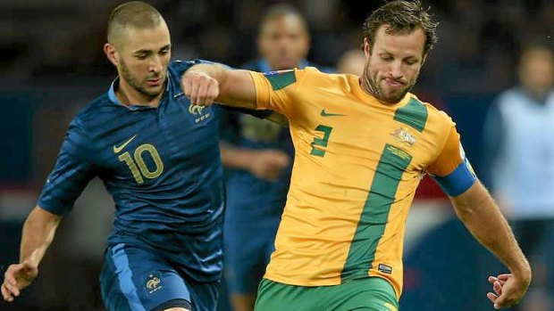 Struggling: Lucas Neill tangles with Karim Benzema of France.