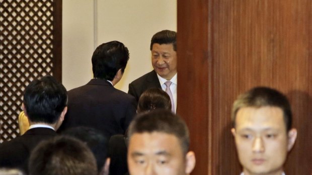 Chinese President Xi Jinping, center, greets Japan's Prime Minister Shinzo Abe on Wednesday. 