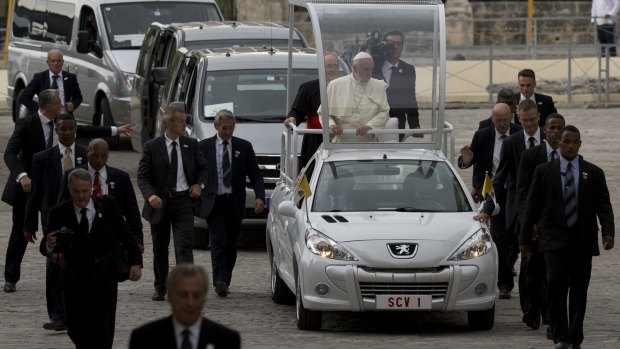 Surrounded by Cuban and Vatican security officers Pope Francis arrives on his popemobile at San Cristobal Cathedral in Havana on Sunday. 