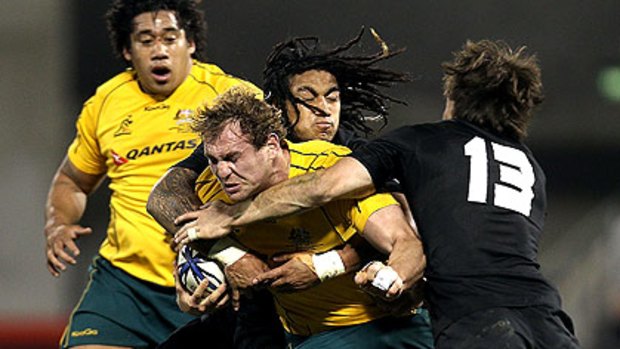 Wallaby Rocky Elsom is gang-tackled by Richie McCaw, Ma'a Nonu and Conrad Smith of the All Blacks in Christchurch last night.