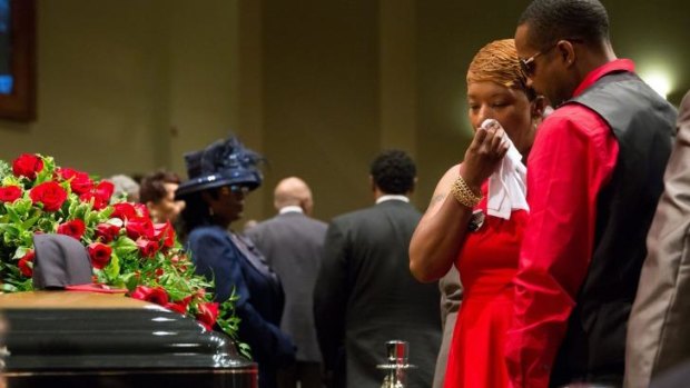 Heartbroken: Lesley McSpadden stands before the casket of her son Michael Brown during his funeral service at Friendly Temple Missionary Baptist Church in St Louis.