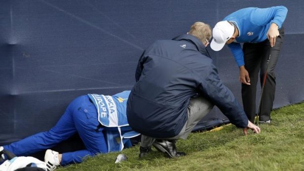 Team Europe's Sergio Garcia searches for his ball under the stand after taking a drop on the 5th hole at Gleneagles.
