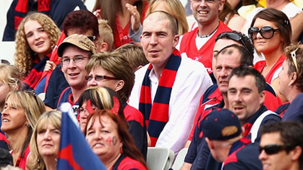 Melbourne president Jim Stynes sits with the Demons' cheersquad.