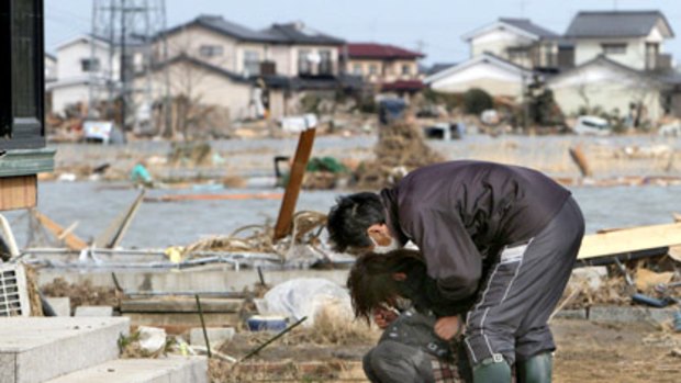 Home and broken-hearted: a couple returns to a quake-shattered home in Watari, Miyagi prefecture.
