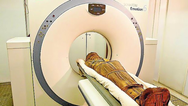 The mummified remains of Esankh enter a CT scanner.