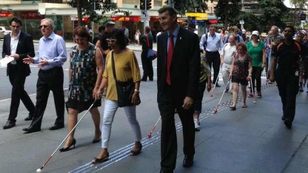 Lord Mayor Graham Quirk tests out the new extension of Brisbane's Braille Trail with some of the city's vision impaired citizens.