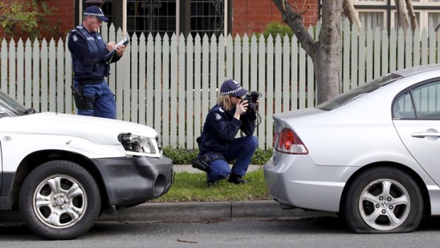 Police survey the damage on Glenferrie Road in Hawthorn, where dozens of cars were vandalised.