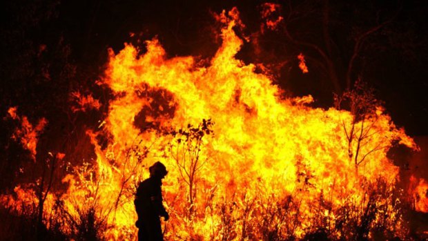 A Queensland rural firefighter monitoring a blaze.