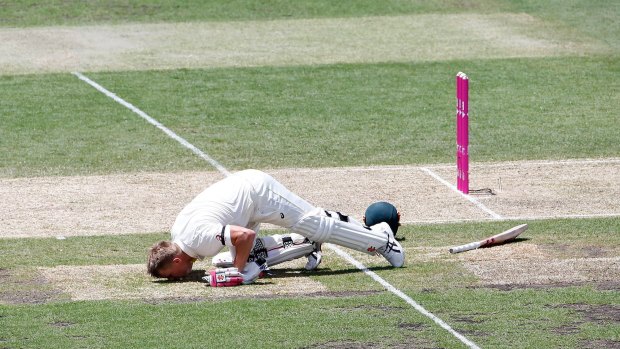 David Warner kisses the ground in tribute to Phillip Hughes after reaching 63 not out.