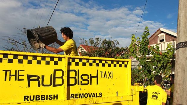 Contractors remove rubbish from the home of Mary Bobolas.