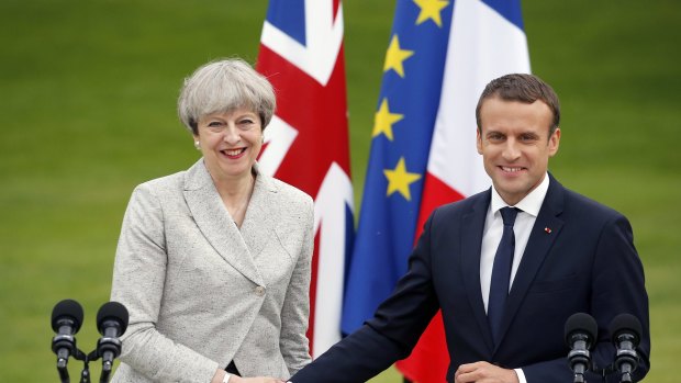 French President Emmanuel Macron shakes hands with British Prime Minister Theresa May.