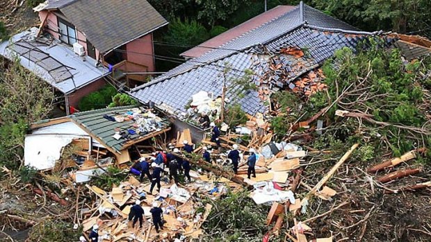 An aerial view shows rescue workers searching among collapsed houses following a landslide caused by Typhoon Wipha.