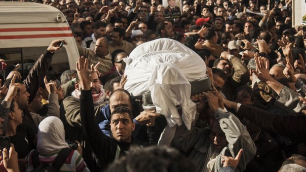 Egyptians carry the coffin of a victim killed from an explosion at police headquarters in Mansoura.