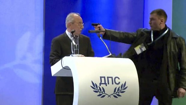 Close call ... Oktai Enimehmedov points a weapon at Ahmed Dogan, leader of the Movement for Rights and Freedoms, during his speech at his party's congress in Sofia at the weekend.
