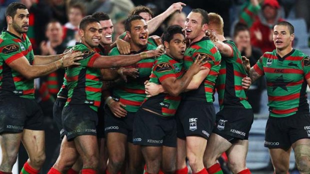 Golden boy ... Rabbitohs halfback Chris Sandow is swamped by teammates after winning the match against great rivals the Roosters with a long-range field goal at ANZ Stadium last night.