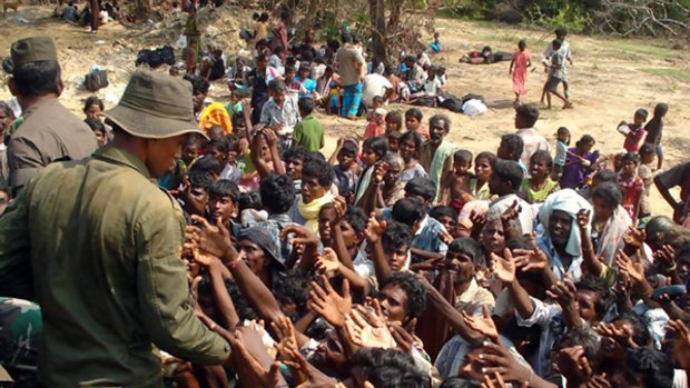 Sri Lankan troops distribute food to refugees that have fled an area called the "no fire zone"  controlled by the Tamil Tigers.