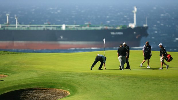 Exposed . . . Peter O'Malley (L) marks his ball as Kevin Stadler waits on the 13th green before play was suspended.