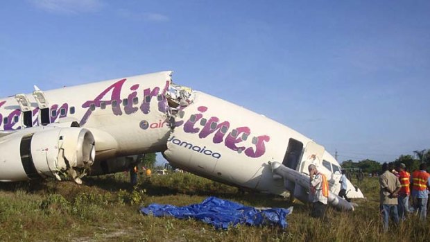 Split in two ... the Caribbean Airlines jet is seen broken at the end of the runway.