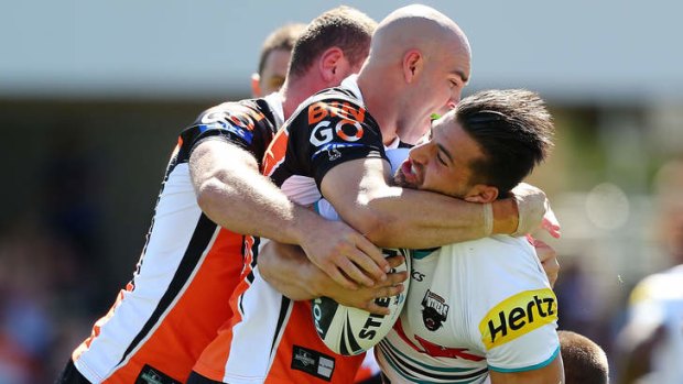 Josh Mansour of the Panthers is tackled by the Tigers defence during the round two NRL match between the Wests Tigers and the Penrith Panthers.