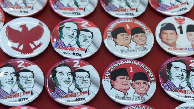 Pins featuring presidential candidates Joko Widodo-Jusuf Kalla and Prabowo Subianto-Hatta Rajasa.