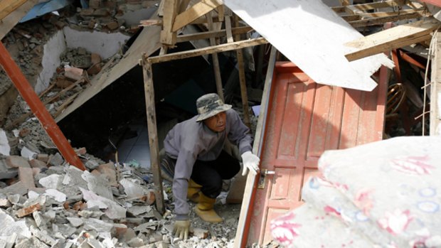 A man clears debris in his damaged house in Pangalengan, West Java, after this week's earthquake.