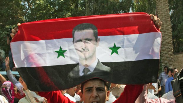 A Syrian man shows support for President Assad during a government-guided tour.